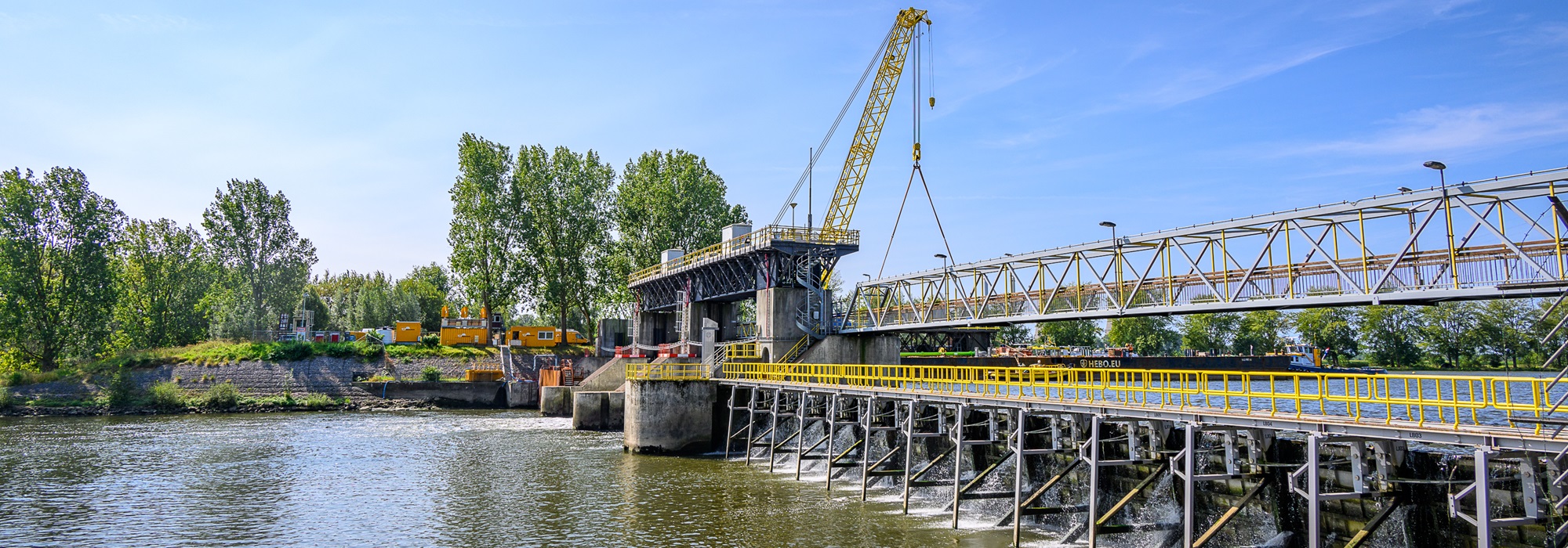 Onderhoudswerkzaamheden aan stuw Linne met kraan en fietsbrug over de Maas.