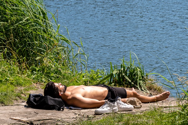 Man sunbathing by the Blue Lake in De IJzeren Man nature and recreational area