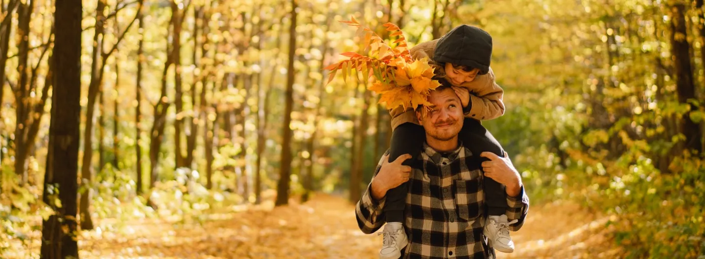 Vader en zoon genieten van een boswandeling in de herfst
