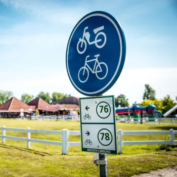 Fietsbord en knooppuntenpaaltje met nummers 76 en 78 in Midden-Limburg, op een zonnige dag bij een recreatiegebied